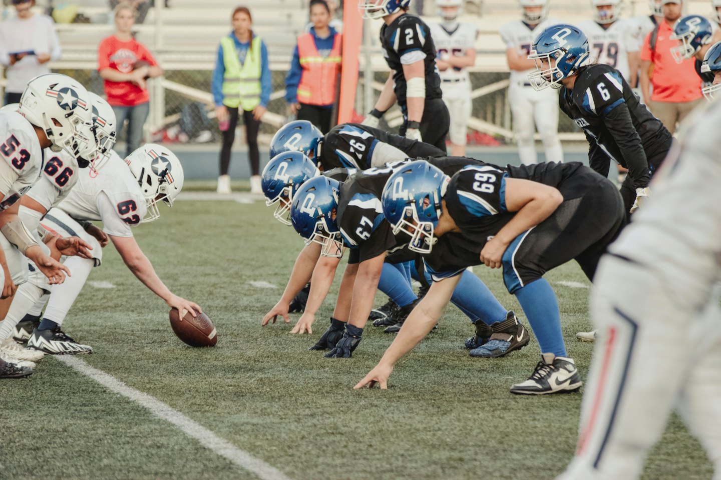 Squadre di calcio in divise a contrasto accovacciate sul campo.