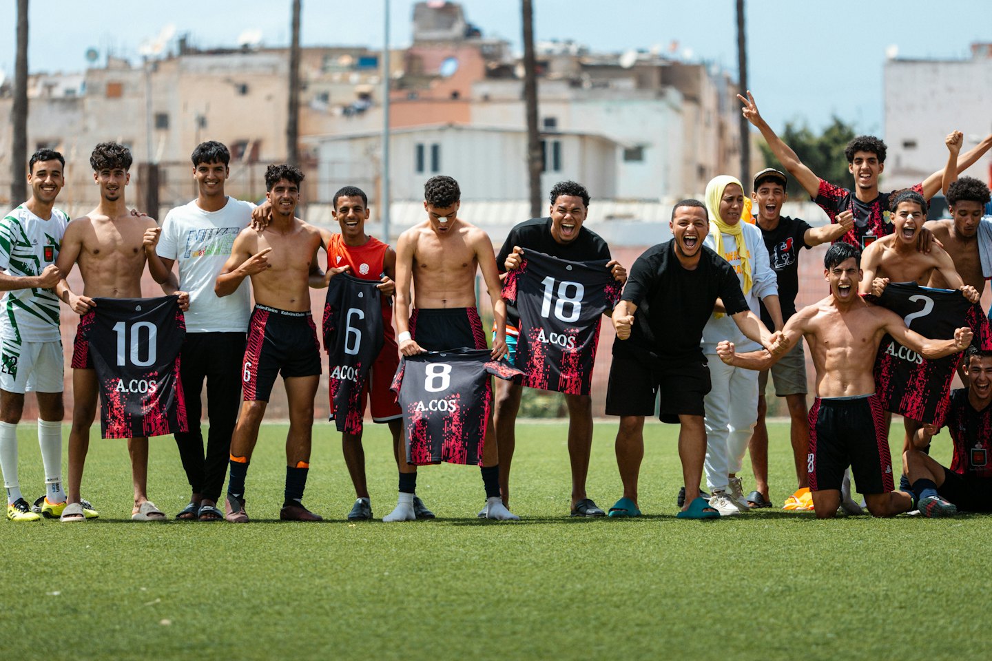Squadra di calcio che festeggia in campo con le nuove maglie.